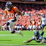 Running back Phillip Lindsay #30 of the Denver Broncos scores a first quarter touchdown on a reception as cornerback Tre Flowers #37 of the Seattle Seahawks falls to the ground during a game at Broncos Stadium at Mile High on September 9, 2018 in Denver, Colorado. (Photo by Dustin Bradford/Getty Images)