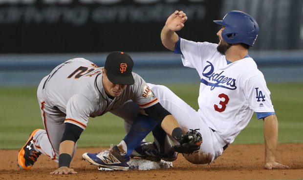 Chris Taylor #3 of the Los Angeles Dodgers slides safely into second after being tagged by Joe Pani...