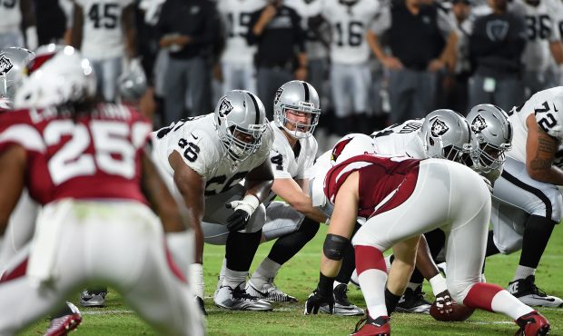 Derek Carr #4 of the Oakland Raiders looks over the defense while calling a play from the line of s...