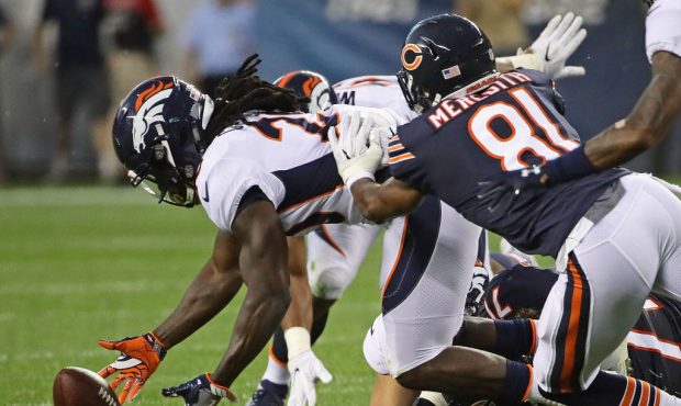 CHICAGO, IL - AUGUST 10:   Jamal Carter #20 of the Denver Broncos recovers a fumble as he's hit by ...