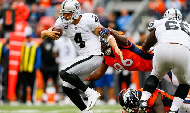 DENVER, CO - OCTOBER 1: Quarterback Derek Carr #4 of the Oakland Raiders tries to avoid a tackle by...