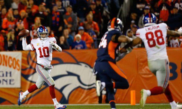 DENVER, CO - OCTOBER 15:  Quarterback Eli Manning #10 of the New York Giants throws a pass on the r...