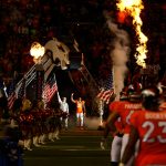 DENVER, CO - NOVEMBER 12:  Cornerback Aqib Talib #21 of the Denver Broncos walks onto the field next to a member of the armed forces during player introductions before a game against the New England Patriots at Sports Authority Field at Mile High on November 12, 2017 in Denver, Colorado. (Photo by Justin Edmonds/Getty Images)