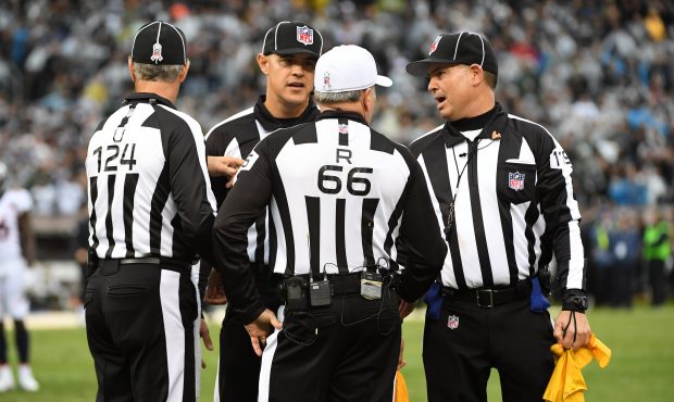 Officials confer after a fight between Michael Crabtree #15 of the Oakland Raiders and Aqib Talib #...