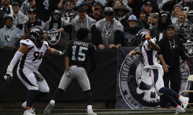 Michael Crabtree #15 of the Oakland Raiders fights with Aqib Talib #21 of the Denver Broncos during...