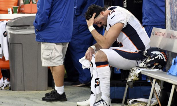 Denver Broncos training staff looks over quarterback Paxton Lynch (12) sits dejected on the bench i...