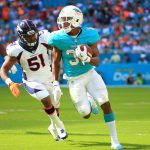 Kenyan Drake #32 of the Miami Dolphins rushes ahead of Todd Davis #51 of the Denver Broncos during the first quarter at the Hard Rock Stadium on December 3, 2017 in Miami Gardens, Florida.  (Photo by Chris Trotman/Getty Images)