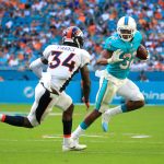 Kenyan Drake #32 of the Miami Dolphins rushes during the third quarter against Will Parks #34 of the Denver Broncos at the Hard Rock Stadium on December 3, 2017 in Miami Gardens, Florida.  (Photo by Chris Trotman/Getty Images)