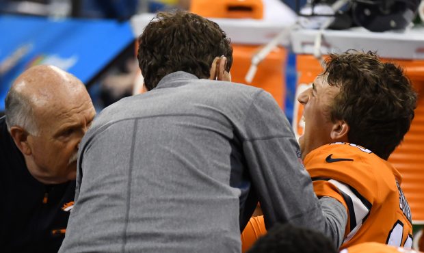 Denver Broncos quarterback Trevor Siemian (13) reacts as he gets his shoulder looked at by team doc...