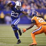 Frank Gore #23 of the Indianapolis Colts pushes off a tackle from Jamal Carter #20 of the Denver Broncos during the second half at Lucas Oil Stadium on December 14, 2017 in Indianapolis, Indiana.  (Photo by Joe Robbins/Getty Images)