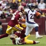 Running back C.J. Anderson #22 of the Denver Broncos runs with the ball past outside linebacker Preston Smith #94 and cornerback Bashaud Breeland #26 of the Washington Redskins in the second quarter at FedExField on December 24, 2017 in Landover, Maryland. (Photo by Patrick McDermott/Getty Images)