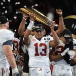 Tua Tagovailoa #13 of the Alabama Crimson Tide holds the trophy while celebrating with his team after defeating the Georgia Bulldogs in overtime to win the CFP National Championship presented by AT&T at Mercedes-Benz Stadium on January 8, 2018 in Atlanta, Georgia.  (Photo by Mike Ehrmann/Getty Images)