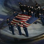 Members of the New York Police and Fire departments hold the American flag found at "Ground Zero" during the Opening Ceremony of the Salt Lake City Winter Olympic Games on February 8, 2002 at the Rice-Eccles Olympic Stadium in Salt Lake City, Utah. (Photo by Donald Miralle/Getty Images)