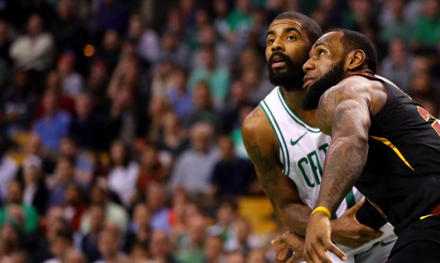 LeBron James #23 of the Cleveland Cavaliers and Kyrie Irving #11 of the Boston Celtics defend each ...