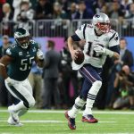 MINNEAPOLIS, MN - FEBRUARY 04:  Tom Brady #12 of the New England Patriots carries the ball defended by Brandon Graham #55 of the Philadelphia Eagles in the first half of Super Bowl LII at U.S. Bank Stadium on February 4, 2018 in Minneapolis, Minnesota.  (Photo by Elsa/Getty Images)