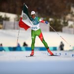 German Madrazo of Mexico holds the flag of Mexico as he approaches the finish line during the Cross-Country Skiing Men's 15km Free at Alpensia Cross-Country Centre on February 16, 2018 in Pyeongchang-gun, South Korea.  (Photo by Matthias Hangst/Getty Images,)