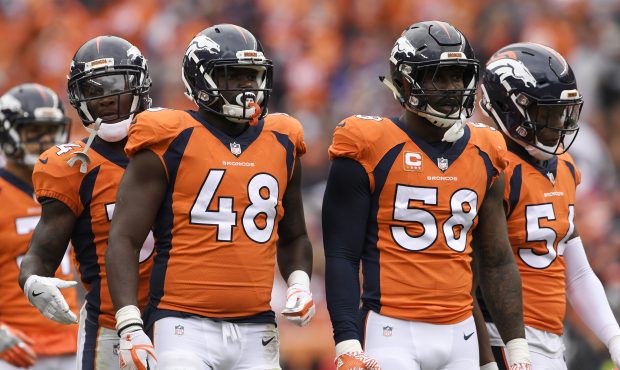 Von Miller (58) of the Denver Broncos is flanked by defensive players Will Parks (34), Shaquil Barr...