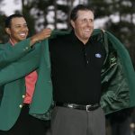 Phil Mickelson (R) of the US gets the green jacket from 2005 winner and compatriot Tiger Wood (L) 09 April 2006 after winning the 2006 Masters Golf Tournament at the Augusta National Golf Club in Augusta, Georgia.  Mickelson won his second Masters in three years in spectacular fashion, firing a three-under par 69 in the final round to defeat South African Tim Clark by two strokes.  AFP PHOTO/TIMOTHY A. CLARY  (Photo credit should read TIMOTHY A. CLARY/AFP/Getty Images)