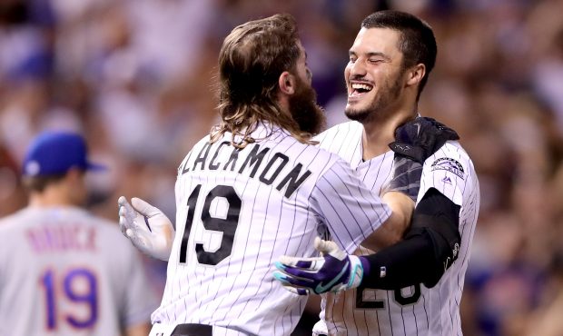 Nolan Arenado #28 of the Colorado Rockies celebrates with Charlie Blackmon #19 after driving in the...