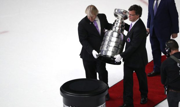 Craig Campbell (right) and Philip Pritchard (left) carry the Stanley Cup onto the ice after the Pit...