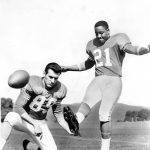 AUG 25 1964; Gene Mingo - Halfback; 6'2", 216 Denver Broncos; BRONCO KICKING ACE BACK ON THE BEAM; Denver Bronco place-kicker Gene Mingo practices his specialty for Friday night's encounter with Kansas City at Fort Worth, Tex. Mingo got zeroed in on field goal range last week as he booted four, including a 55-yarder, in Denver's 32-20 surprise of Houston. Bill Groman holds the ball while Mingo blasts another one through.;  (Photo By The Denver Post via Getty Images)