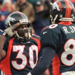 Denver Broncos player Terrell Davis (30) gives the Broncos salute to teammate Rod Smith after Davis scored his first touchdown in the first quarter of their AFC Wild Card playoff game with the Jacksonville Jaguars on Dec. 27 at Mile High Stadium in Denver.  (Photo by Doug Collier/AFP/Getty Images)