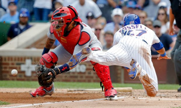 Addison Russell #27 of the Chicago Cubs dives home to score on an RBI single by Ben Zobrist #18 (no...