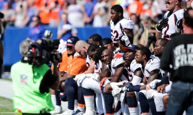 Denver Broncos players kneel during the national anthem before an NFL game against the Buffalo Bill...