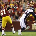 LANDOVER, MD - AUGUST 24: Quarterback Colt McCoy #12 of the Washington Redskins takes a hit after releasing a pass by linebacker Von Miller #58 of the Denver Broncos in the first half during a preseason game at FedExField on August 24, 2018 in Landover, Maryland. (Photo by Patrick Smith/Getty Images)