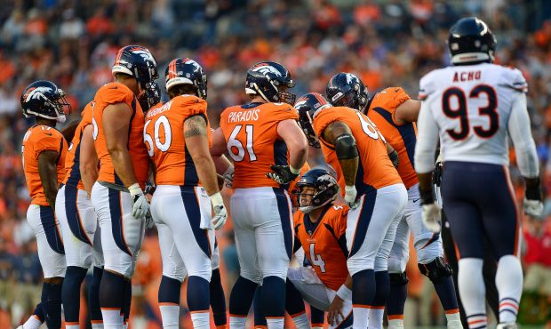 The Denver Broncos offense huddles around quarterback Case Keenum #4 during an NFL preseason game a...