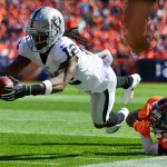 DENVER, CO - SEPTEMBER 16:  Wide receiver Martavis Bryant #12 of the Oakland Raiders dives forward after being hit by defensive back Tramaine Brock #22 of the Denver Broncos int he second quarter of a game at Broncos Stadium at Mile High on September 16, 2018 in Denver, Colorado. (Photo by Dustin Bradford/Getty Images)