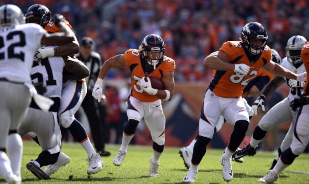 Running back Phillip Lindsay (30) of the Denver Broncos finds a hole and gains some yards during th...
