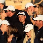 Rickie Fowler of the United States looks on as Kim Johnson, Zach Johnson, J.B. Holmes, Erica Holmes, Jimmy Walker, Erin Walker, Jordan Spieth, Annie Verret, Justine Reed and Patrick Reed celebrate during singles matches of the 2016 Ryder Cup at Hazeltine National Golf Club on October 2, 2016 in Chaska, Minnesota.  (Photo by Sam Greenwood/Getty Images)