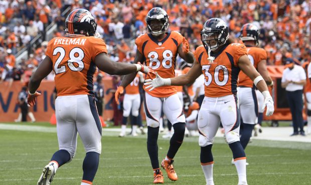 Royce Freeman (28) of the Denver Broncos celebrates scoring a touchdown with Phillip Lindsay (30) d...