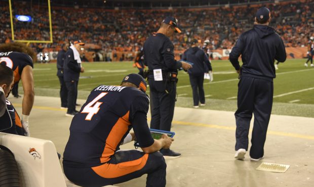 Denver Broncos quarterback Case Keenum (4) watches a tablet on the sidelines before the start of th...
