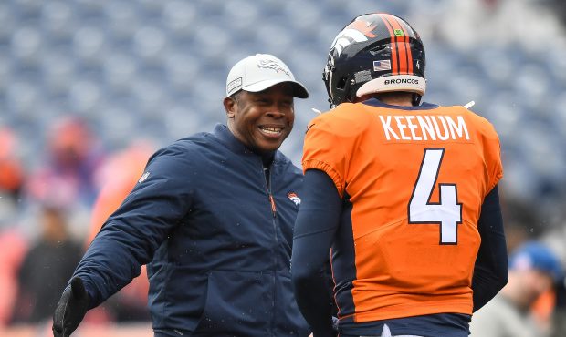 Head coach Vance Joseph of the Denver Broncos greets quarterback Case Keenum #4 on the field as pla...