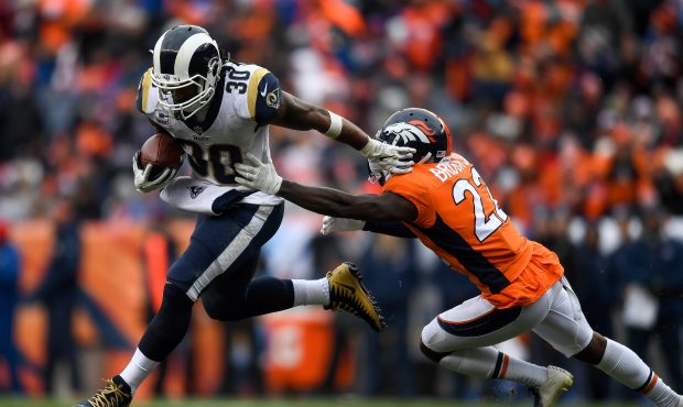 Running back Todd Gurley #30 of the Los Angeles Rams rushes against defensive back Tramaine Brock #...