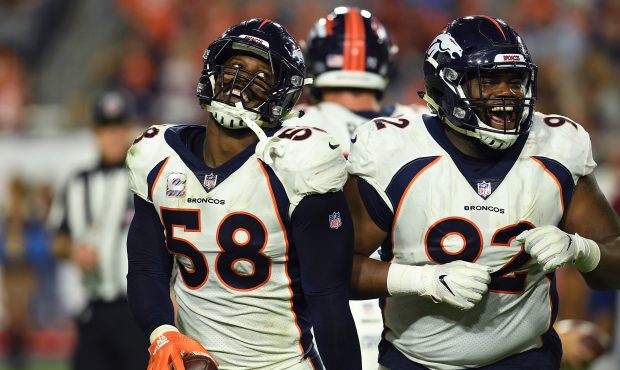Von Miller #58 and Zach Kerr #92 of the Denver Broncos celebrate Millers strip and recovery of a fu...
