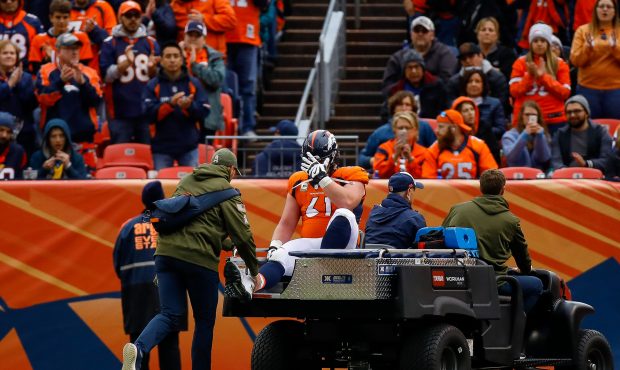 Center Matt Paradis #61 of the Denver Broncos puts his hand on his head as he is carted of the fiel...