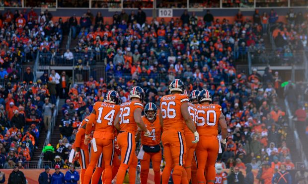 The Denver Broncos offense huddles around quarterback Case Keenum #4 in the second quarter of a gam...