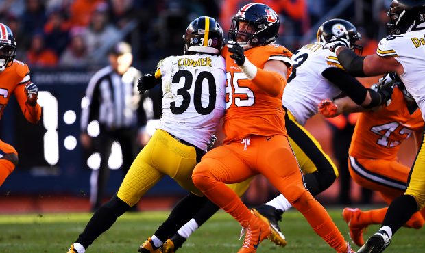 Denver Broncos defensive end Derek Wolfe #95 stops Pittsburgh Steelers running back James Conner #3...