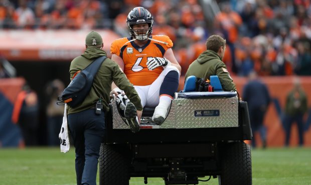 Matt Paradis #61 of the Denver Broncos is driven off the field after being injured against the Hous...