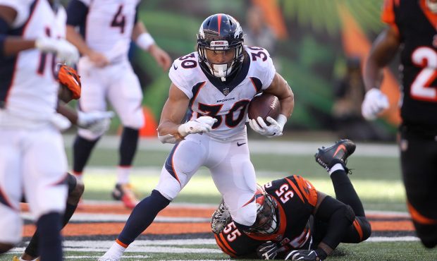 Phillip Lindsay #30 of the Denver Broncos slips out of an attempted tackle by Vontaze Burfict #55 o...