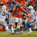 Running back Royce Freeman #28 of the Denver Broncos escapes a tackle attempt by linebacker Hayes Pullard #50 of the Los Angeles Chargers in the second quarter of a game at Broncos Stadium at Mile High on December 30, 2018 in Denver, Colorado. (Photo by Justin Edmonds/Getty Images)