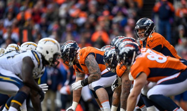 Quarterback Case Keenum #4 of the Denver Broncos lines up behind offensive guard Connor McGovern #6...