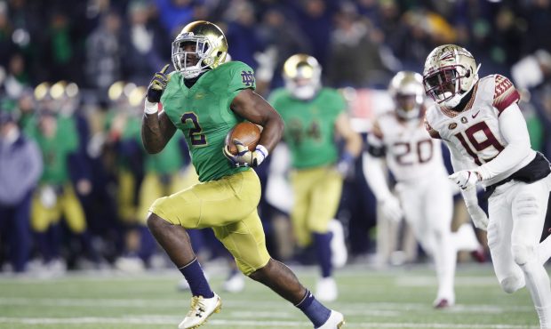 Dexter Williams #2 of the Notre Dame Fighting Irish breaks a tackle on his way to a 58-yard touchdo...
