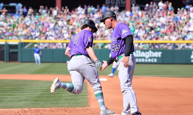 Rockies Pat Valaika gets a handshake from coach Ron Gideon as he trots the bases after hitting a ho...