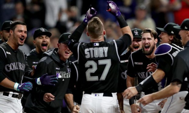 Trevor Story #27 of the Colorado Rockies is met at the plate by his teammates after hitting a 2 RBI...