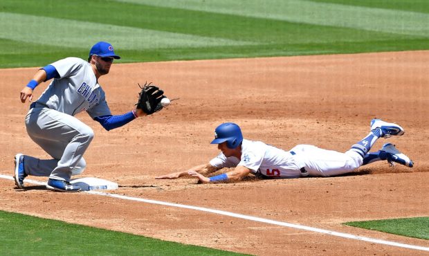 Austin Barnes #15 of the Los Angeles Dodgers beats the throw to David Bote #13 of the Chicago Cubs ...