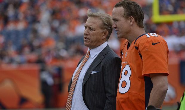 Peyton Manning talks with John Elway at the end of the fourth quarter during the Denver Broncos gam...